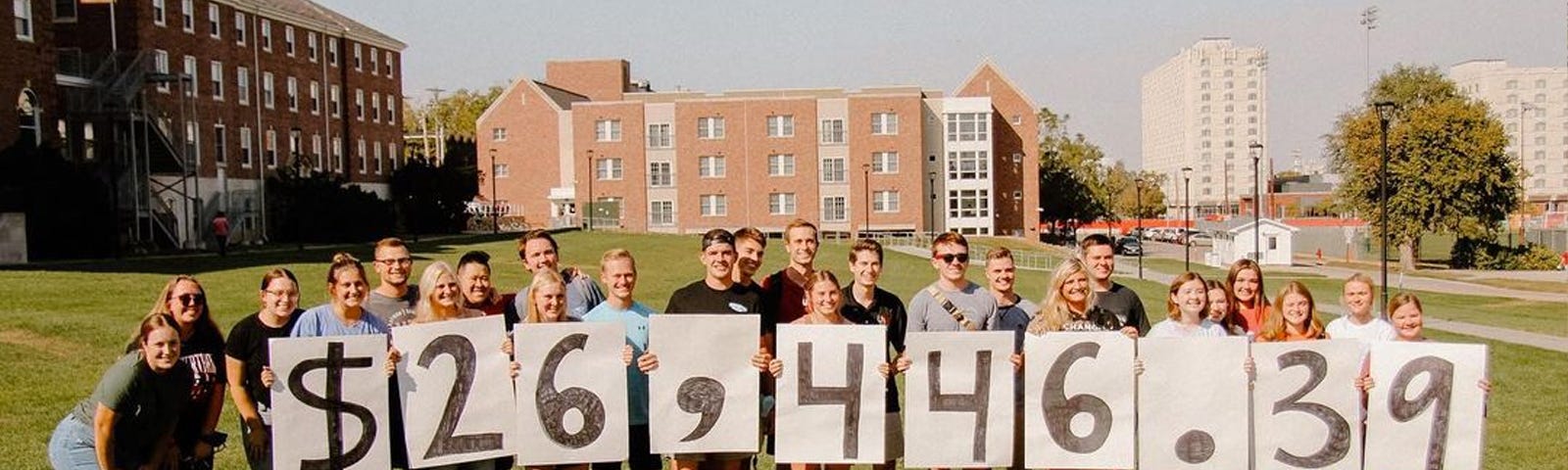 Dance Marathon members pose for a photo holding numbers that spell out the donation they raised in October: $26,446.39