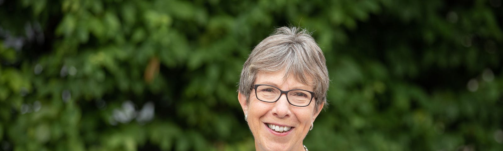 Photo of Marg Heidebrecht ’76 outside in front of trees.