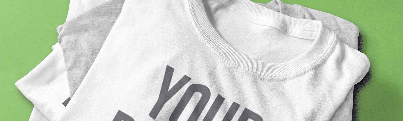 Image of a product mockup used for print on demand business, showing a stack of shirts with the print “your design”.