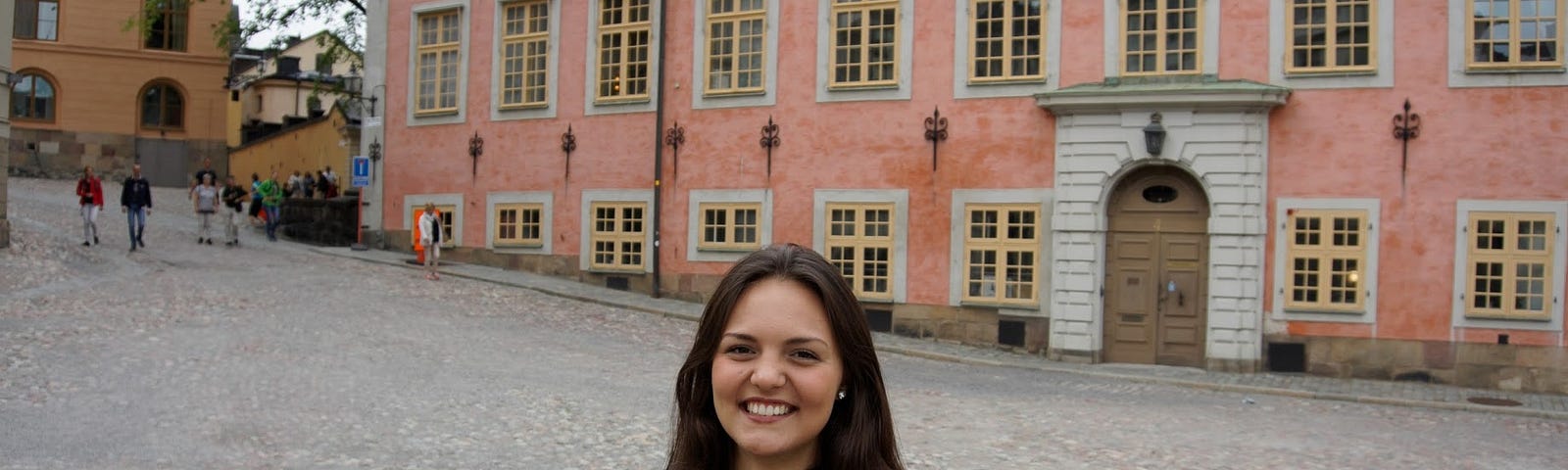 A girl stood outside a large pink building