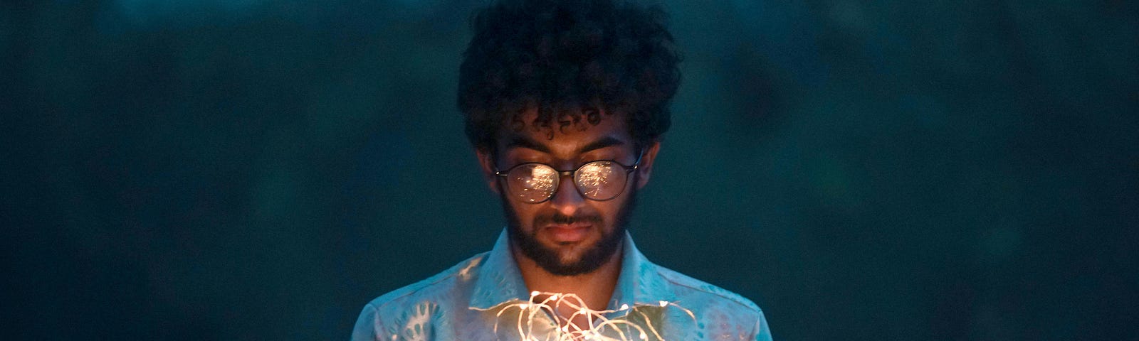 A young man reads from a magical-looking book