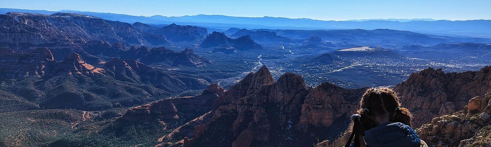 Woman hiking in the mountains wearing a jacket and REI backpack