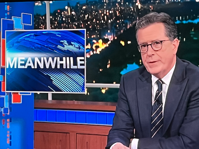 a photo of Stephen Colbert during the Late Show with Stephen Colbert. He sits next to a graphic that says Meanwhile.