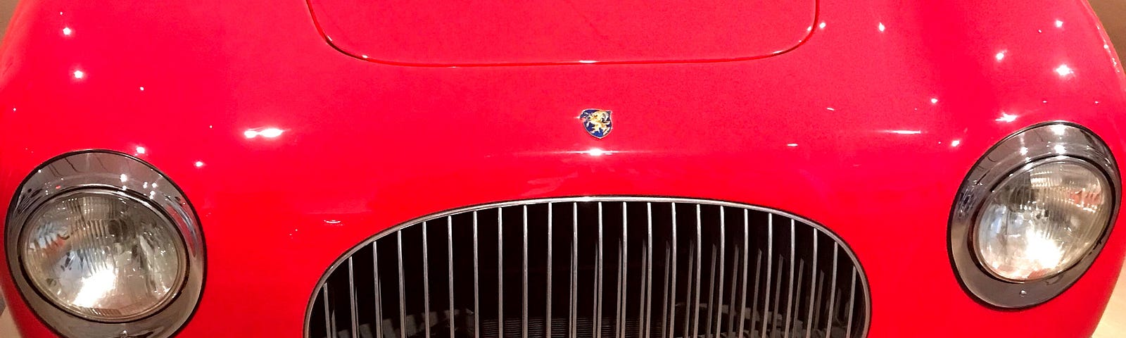 The red hood and grill of a Porsche.
