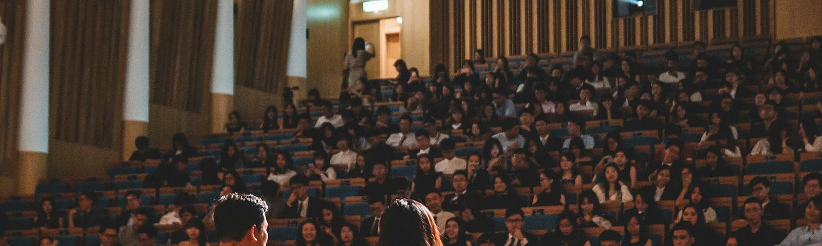 A man standing behind a podium in front of a large audience