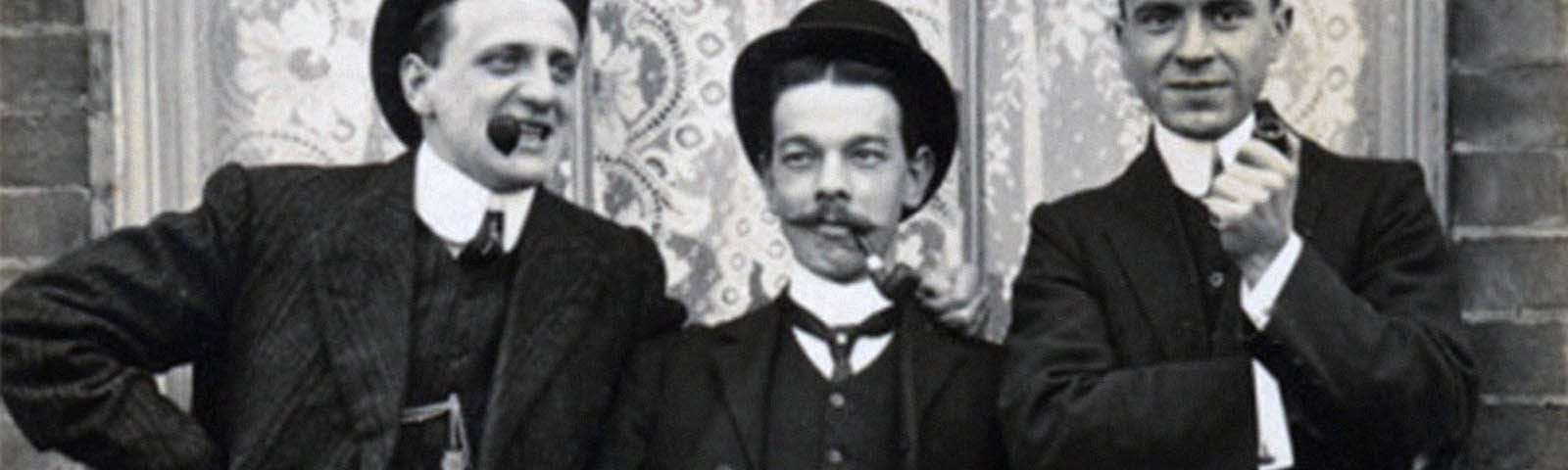 Early 20th century black and white photograph of three well dressed Western gentlemen