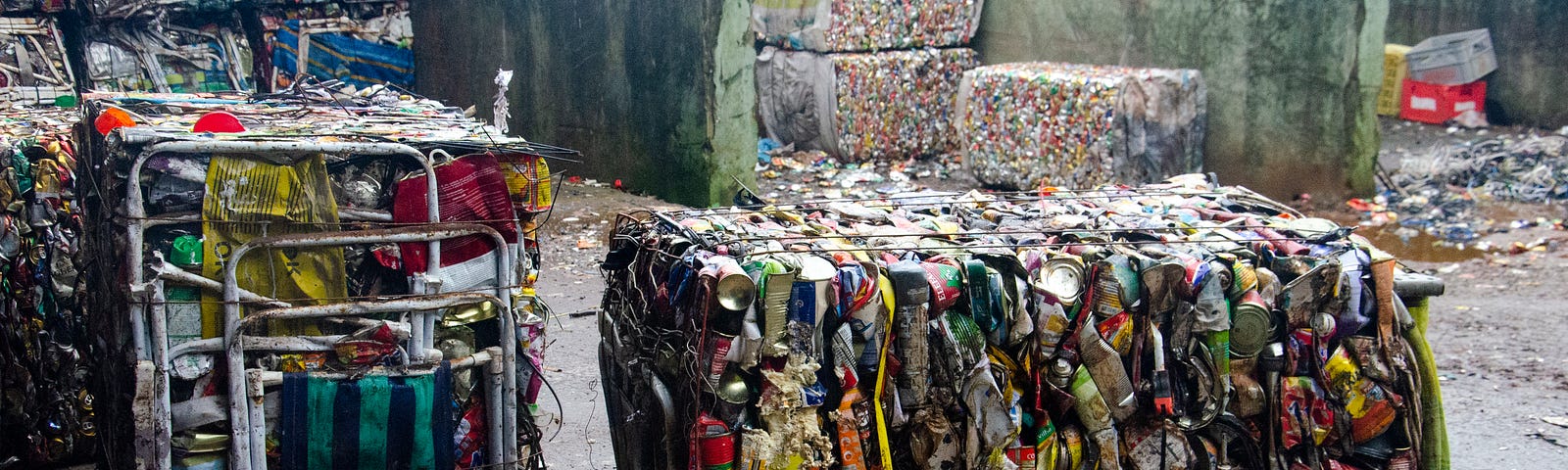 Blocos de lixo reciclável composto por cadeiras, garrafas e outros resíduos.