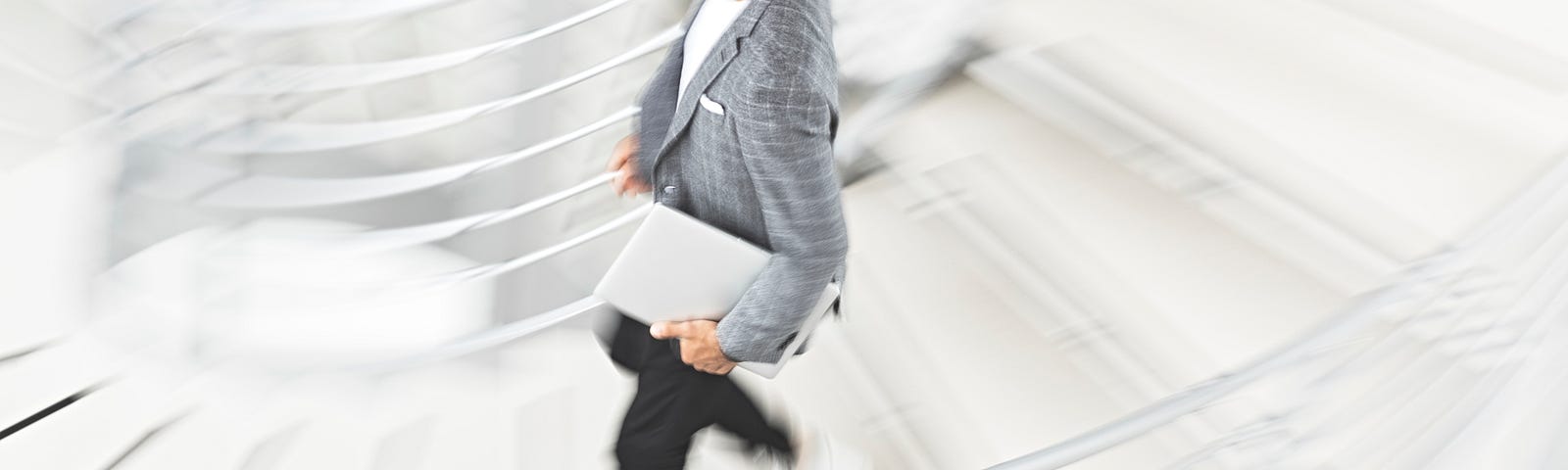 A young man walking briskly down stairs.