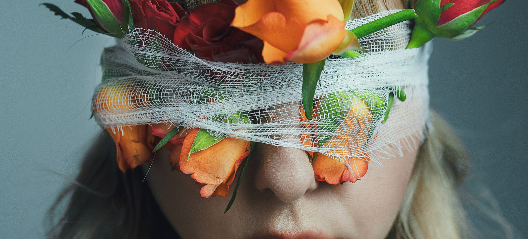 woman blindfolded with flowers around her head