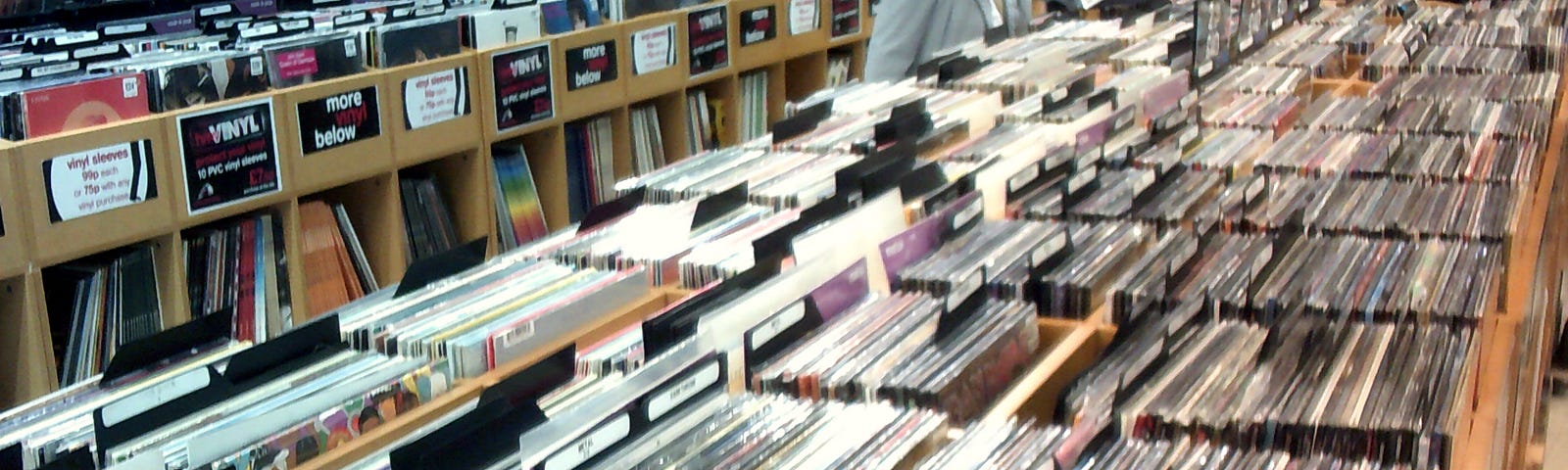 Image of a customer browsing the racks containing long playing vinyl records in a High Street music retail store