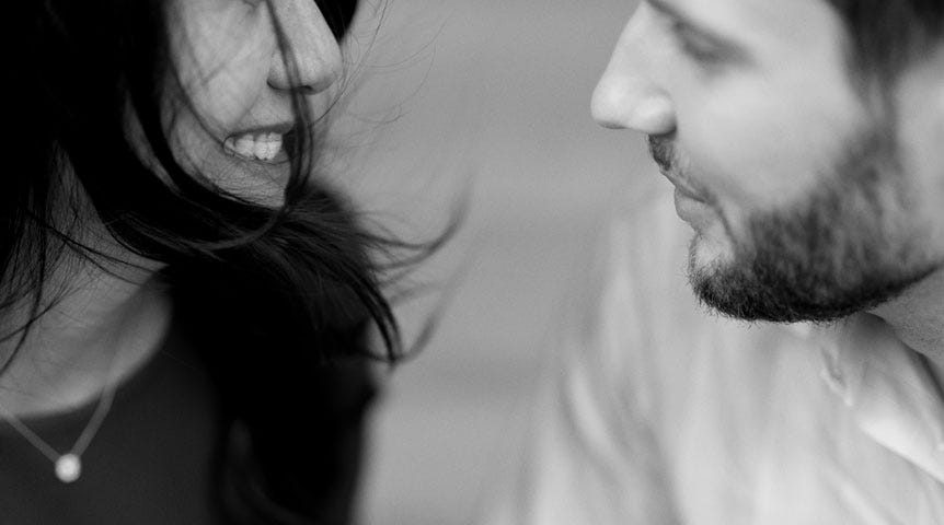 Young man and woman smiling at each other