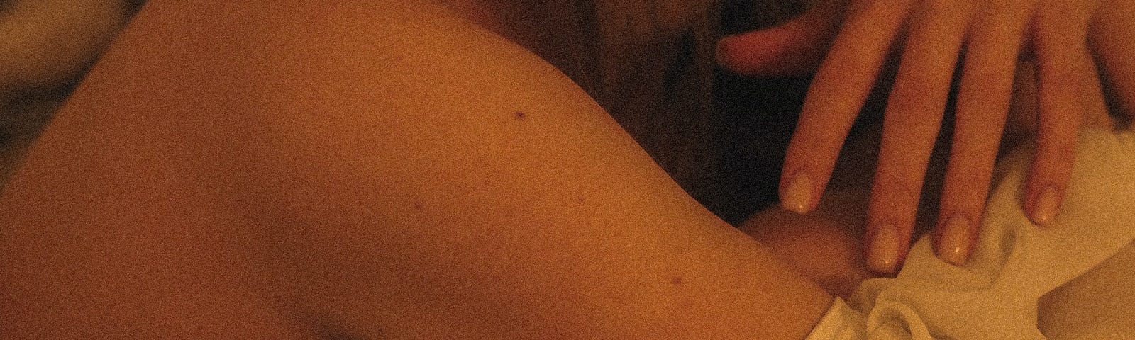 A feminine woman’s skin. Sleeve down showing her shoulder blade.