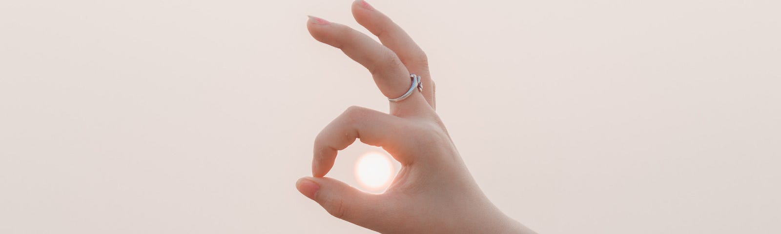 Hand symbol for a-okay over the sun in the sky