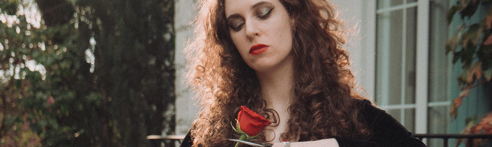 Woman Standing in Garden Cutting Red Rose with Garden Shears/Scissors