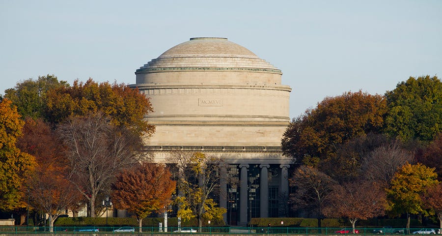 MIT Dome next to trees behind the Charles River.