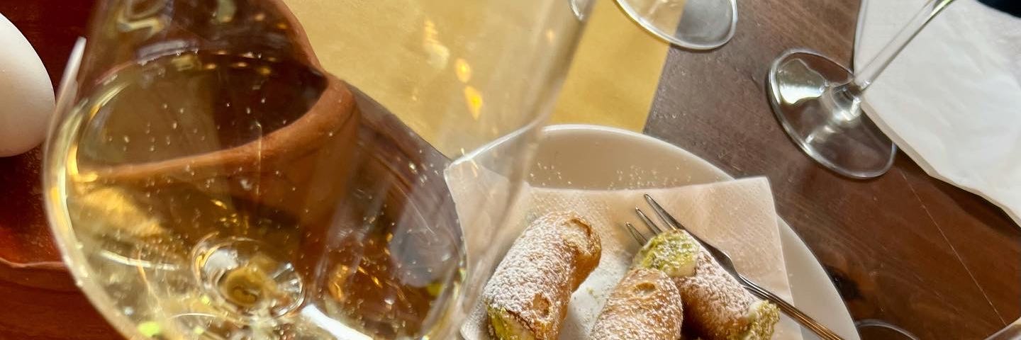 a vineyard tasting of white wine and delicious canoli on a table