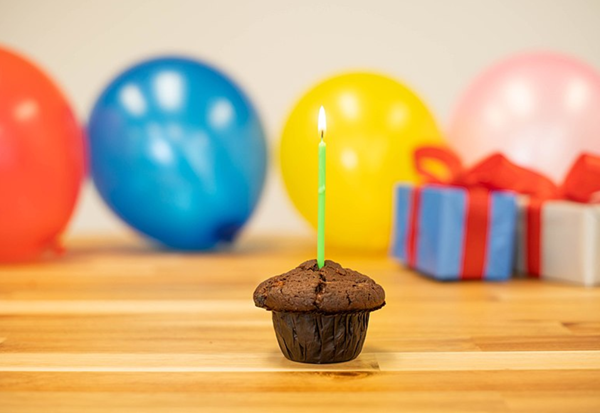 Image of birthday cake and balloons.