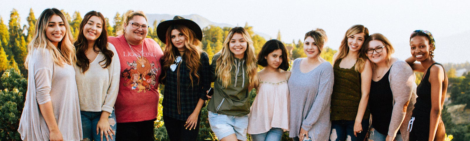 Group of women standing together in a line outside in the sun