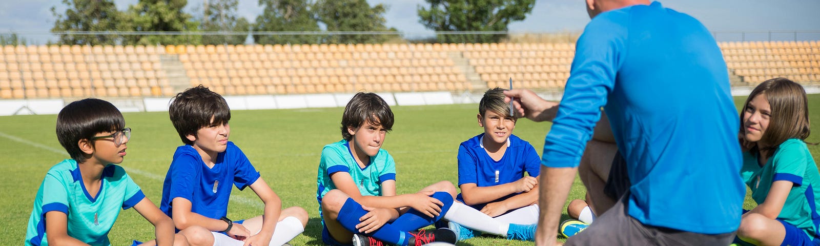 A Coach Teaching Children at a Soccer Field