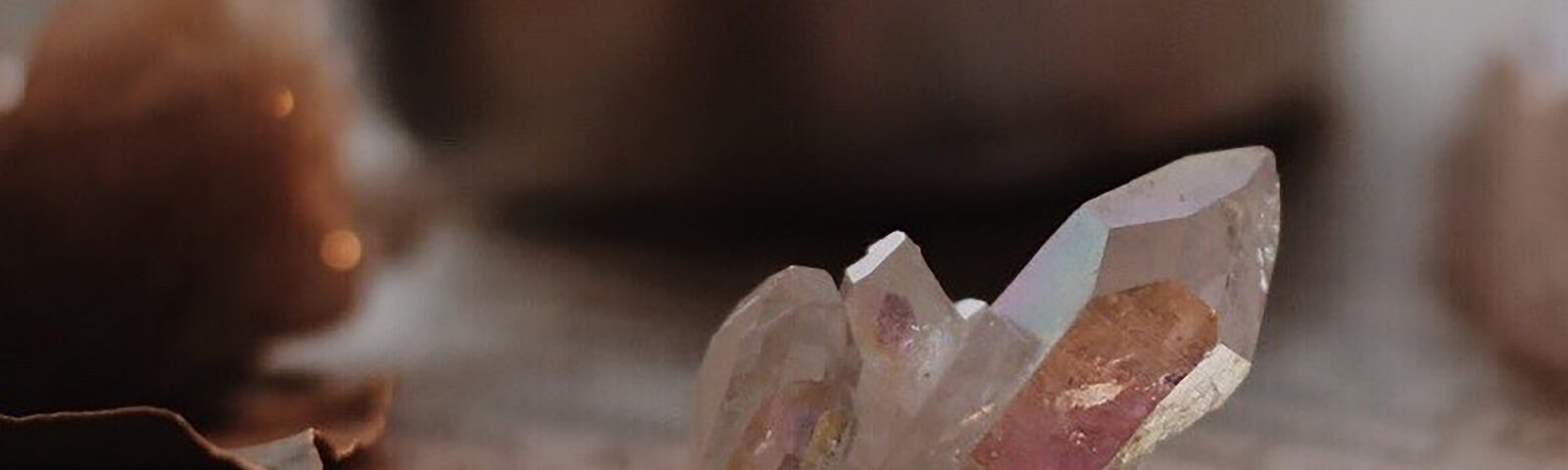 Clear quartz point sitting on a book dimly lit by a candle.