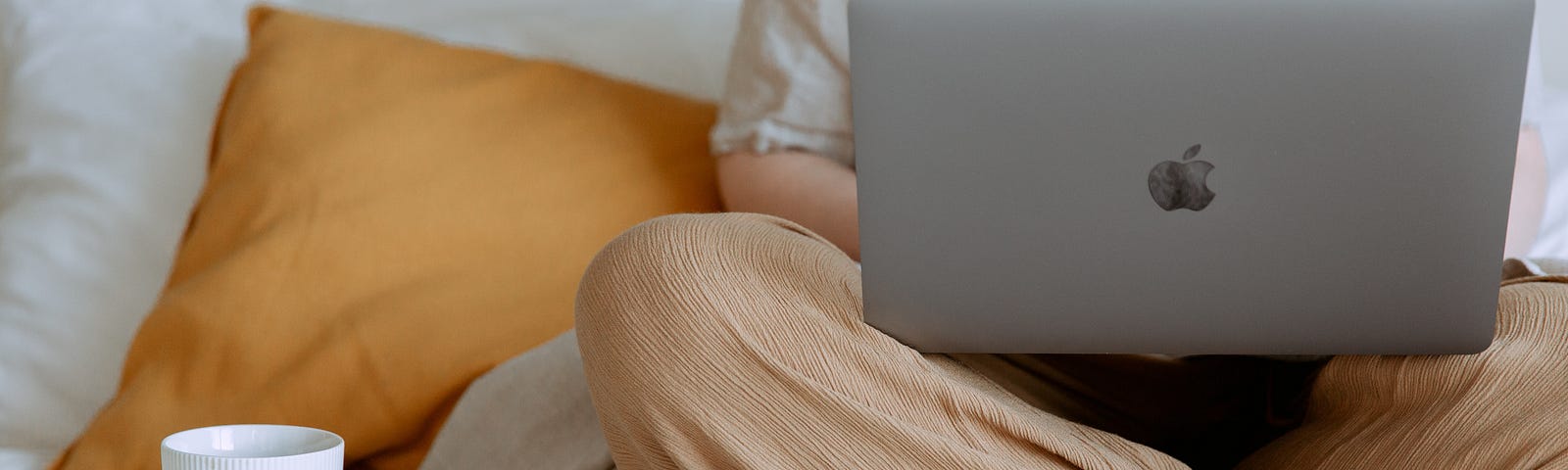 woman working on a laptop on her bed