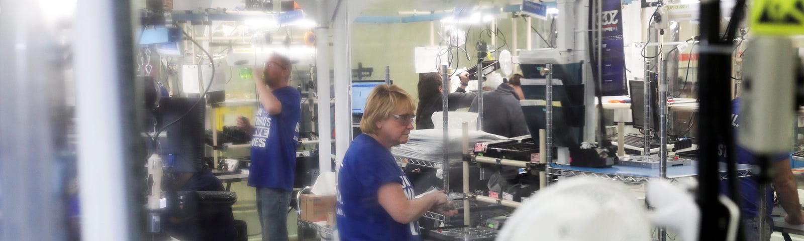 Employees assemble ventilator components behind a plastic curtain at a GE Healthcare manufacturing facility in Madison, Wisconsin, April 21, 2020. Photo by Daniel Acker/Reuters