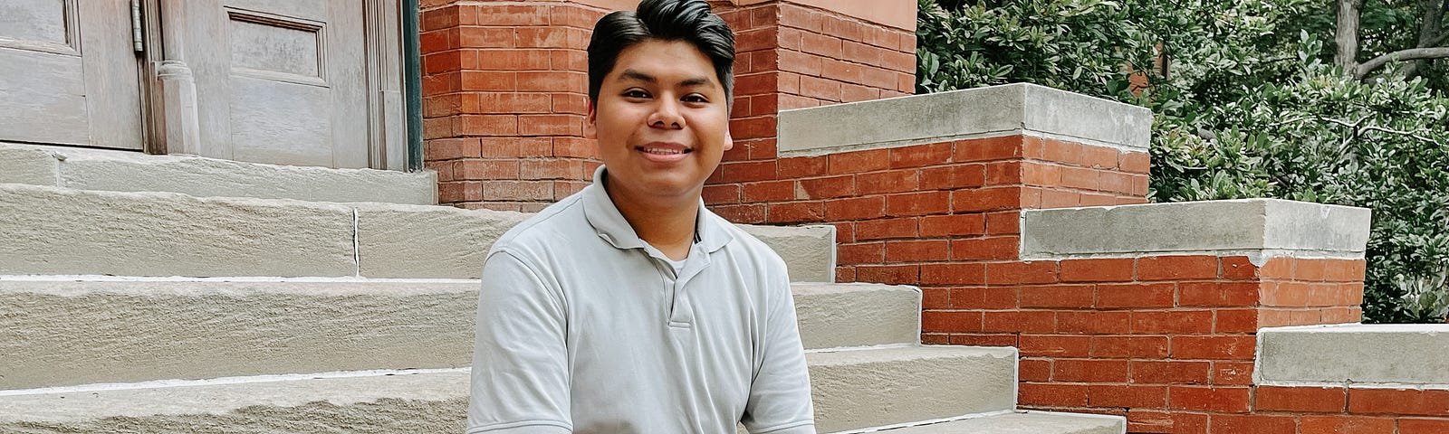 Edgar smiles for a photo on the steps of Architecture Hall