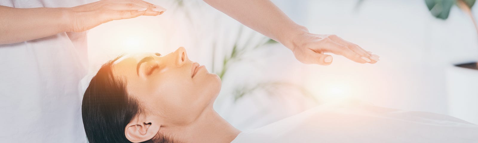 Women receiving reiki healing from a reiki practitioner