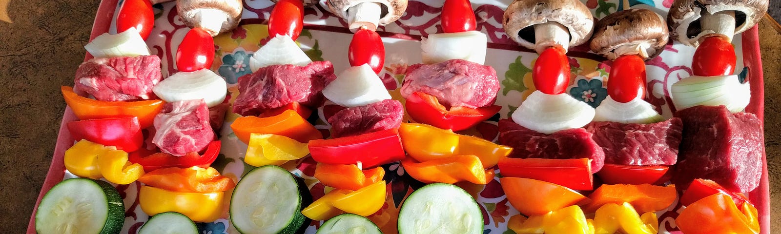 This photo shows kabobs with vegetables and meat on a platter.