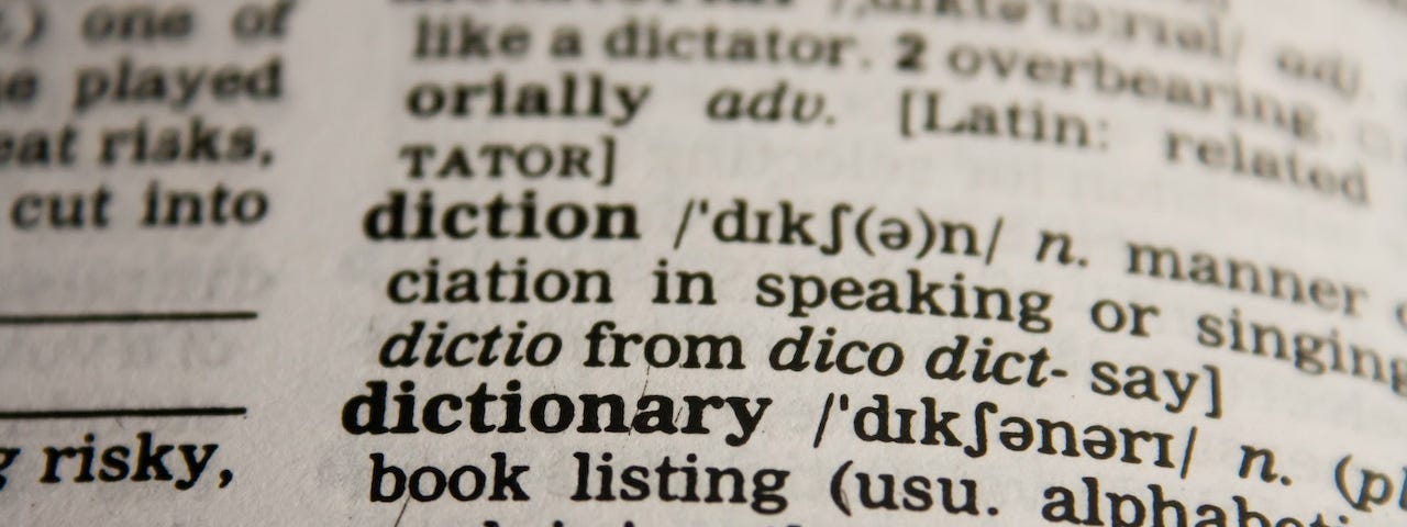 Close-up of a page in a dictionary, with the words diction and dictionary in focus.