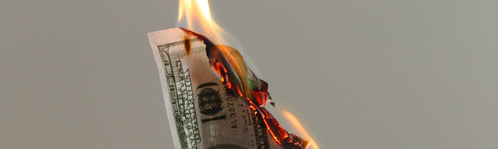 Three one hundred dollar bills on fire.