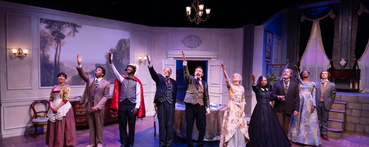 Ten actors stand in a line on stage for a curtain call, dressed in full period costume and raising their right arms to salute the production’s stage manager.