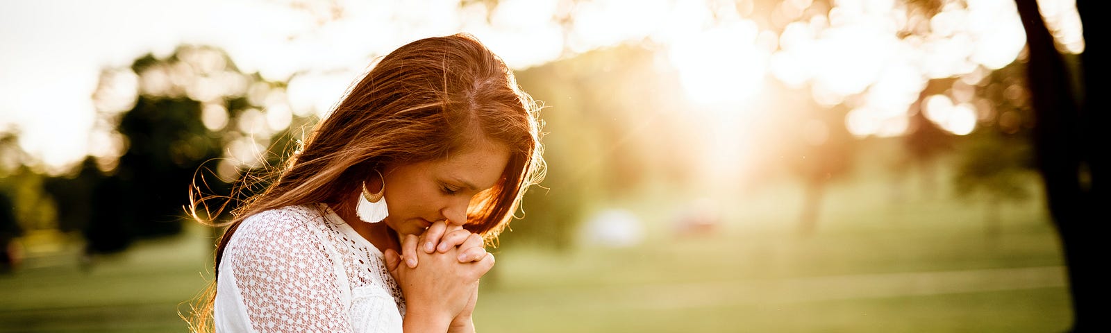Woman with hands by her faith showing the power of forgiveness