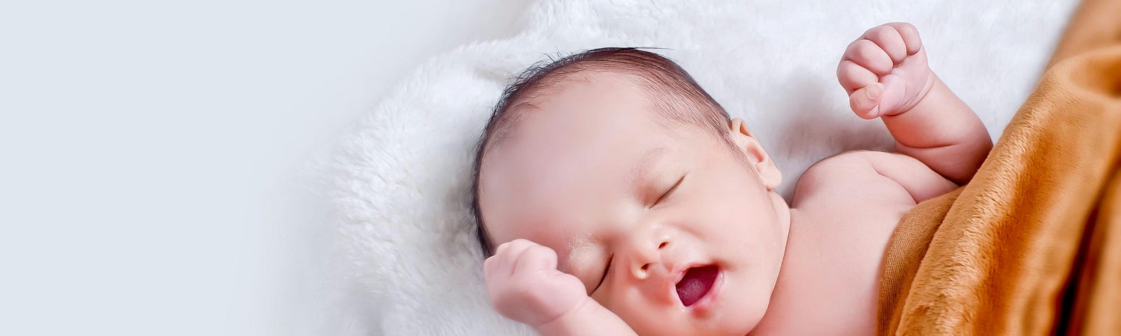 Newborn baby stretching and opening his mouth