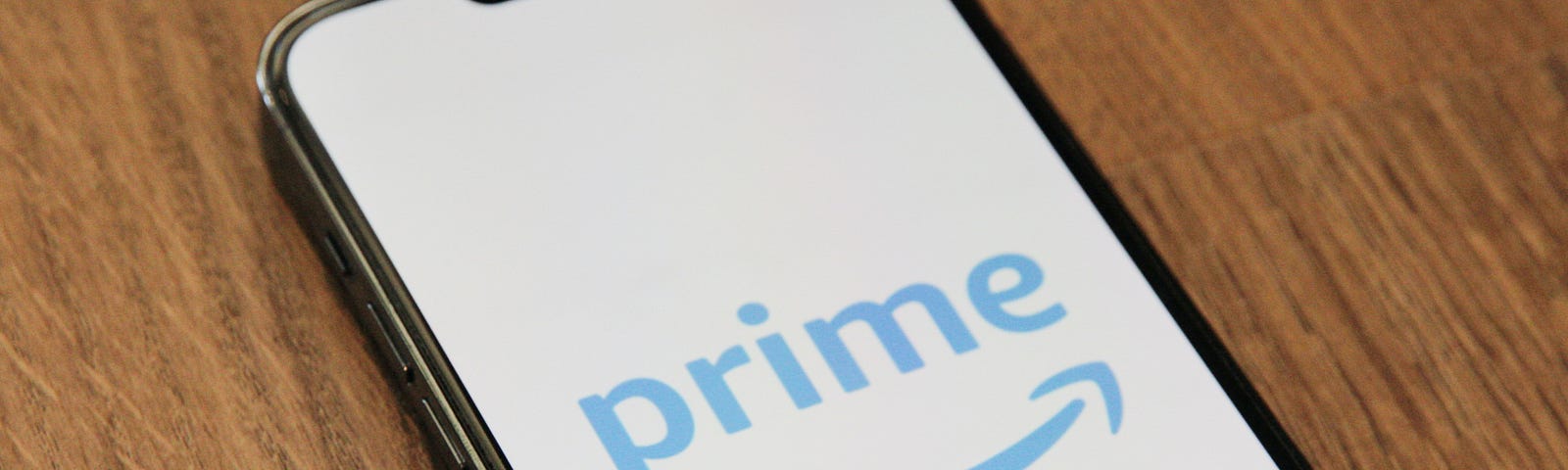 IMAGE: A smartphone on a table with the Amazon Prime logo in blue on a white screen