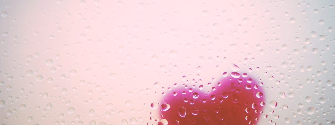 A red heart civered in raindrops