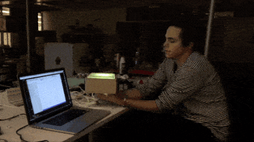 Animated gif showing an open macbook, the prototype and color-changing lightbulb