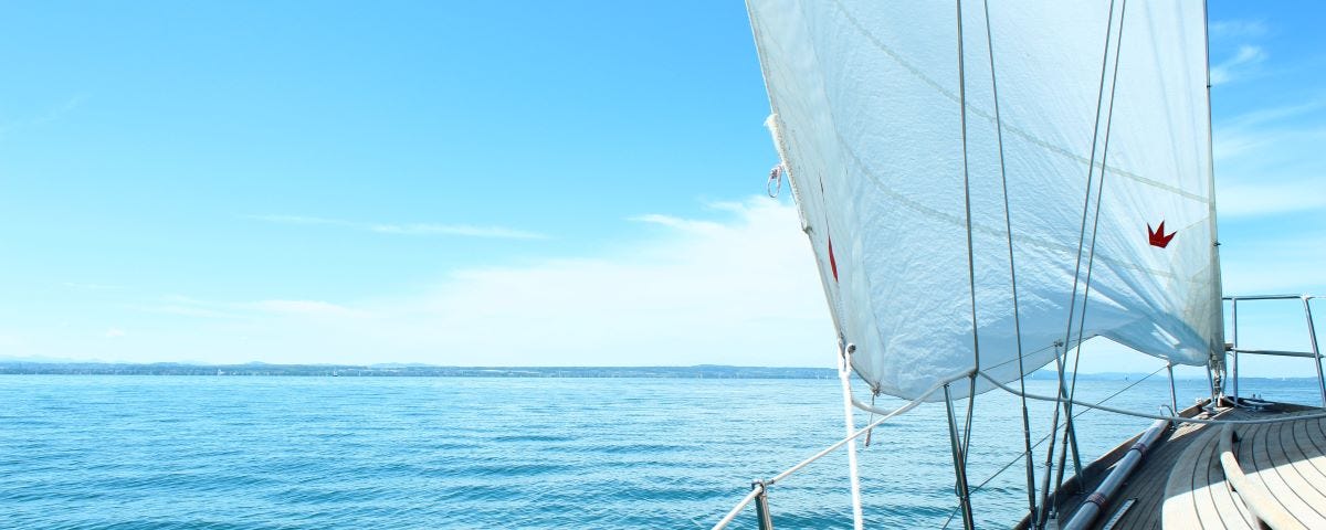 a boat on a stunning blue sea that’s encouraging you to sail toward your dreams