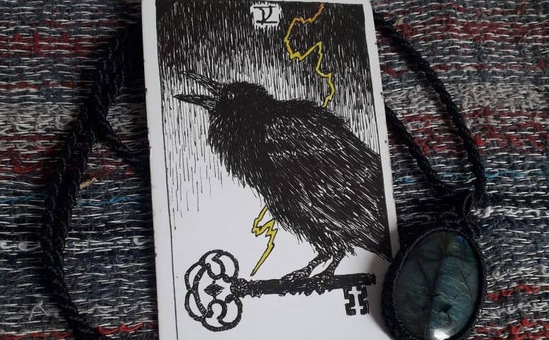 O Corvo, a Chave e o Raio, representando a energia do Arcano V (5) do Tarot, no baralho The Wild Unknow: A Espiritualidade.