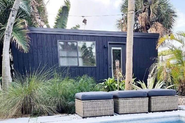 An in-place eEscape home pictured near a pool and in a tropical climate.