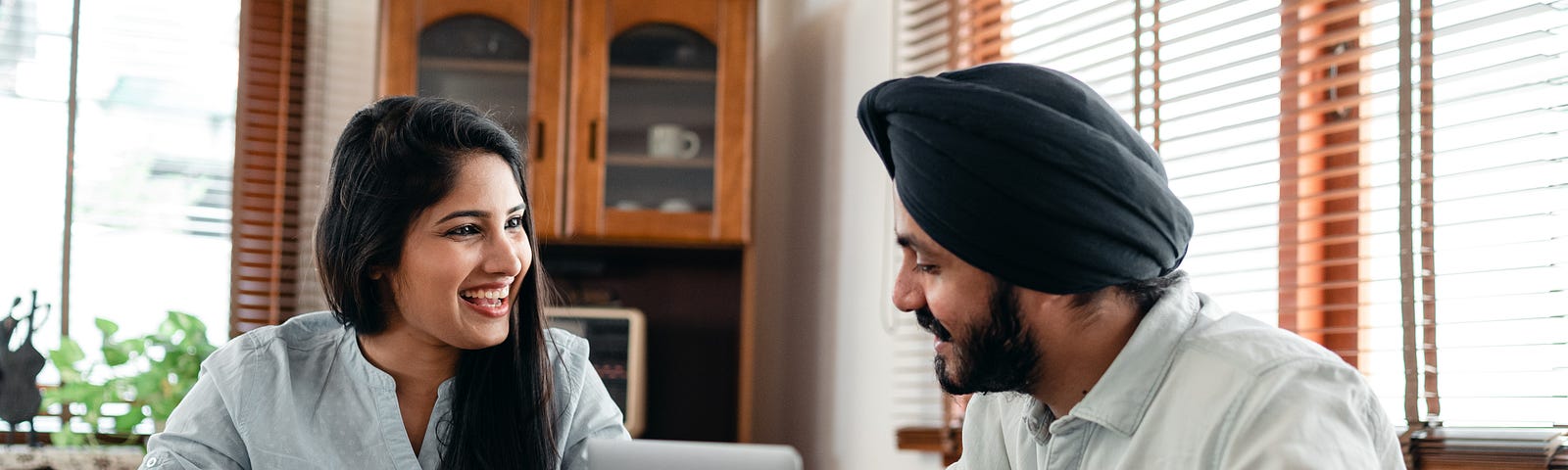 Cheerful couple discussing business issues at home