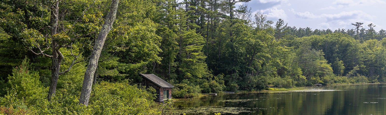 Photo of a ramshackle cabin near a lake in New Hampshire.