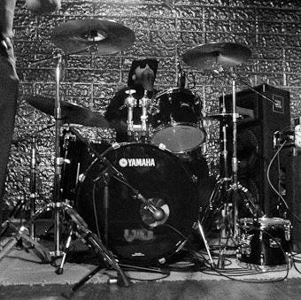 Black and white photo of me and my drums on a stage.