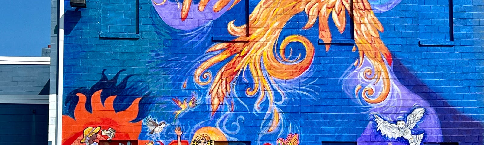 Mural with phoenix rising; six figures release birds to the sky