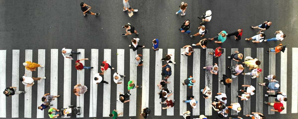 A top view photo shows many people going through the pedestrian crosswalk.