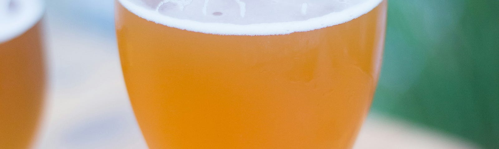 An outdoor shot of a Hefeweizen beer on a picnic table.