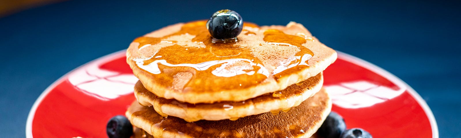 Pancakes on a plate with blueberries and banana.