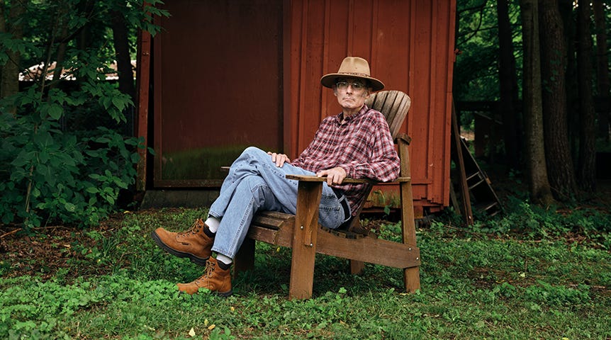 Senior man sitting in wooden chair in yard