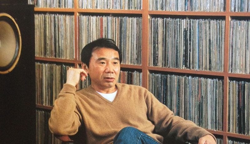 Haruki Murakami sitting in front of his vast collection of records