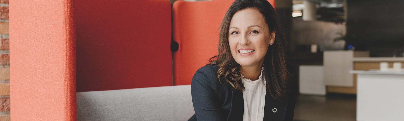 Magda Warshawksi ’04 is sitting on a cubicle sofa at her DIALOG office in Edmonton.